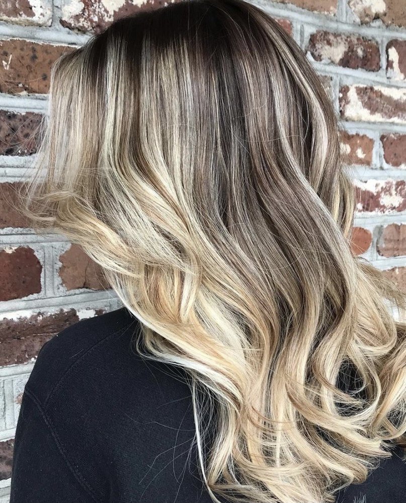 Rooted blonde balayage swept to one side